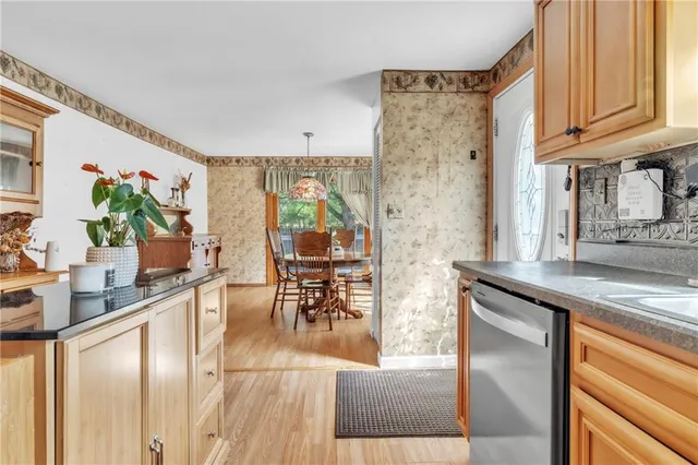 a kitchen with stainless steel appliances kitchen island granite countertop a table chairs in it and wooden floor