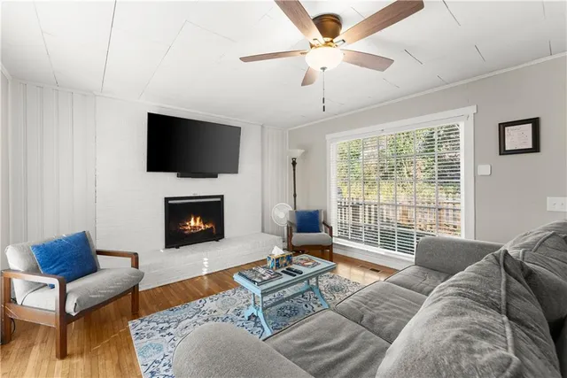 a living room with furniture a flat screen tv and a fireplace