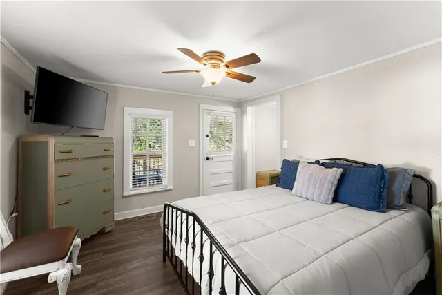 a bedroom with a large bed and a flat tv screen on dresser