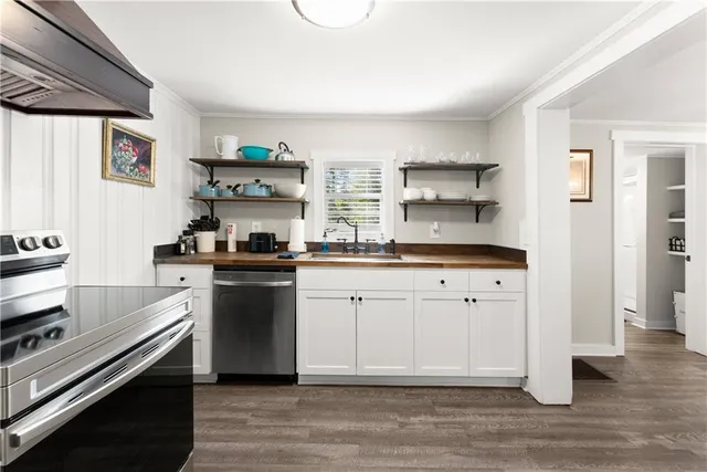 a kitchen with stainless steel appliances white cabinets and a window