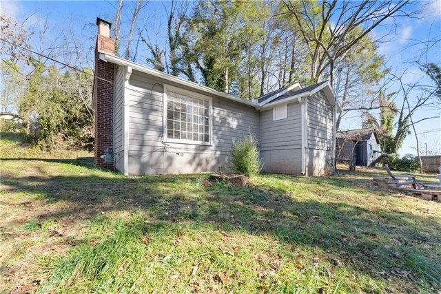 a view of a backyard with plants and large tree