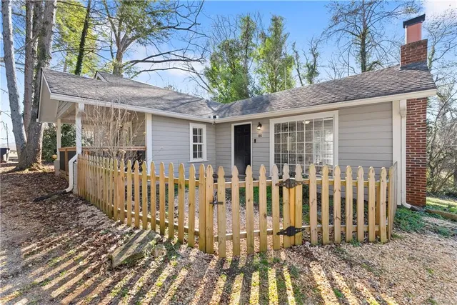 a view of a house with a small yard and wooden fence