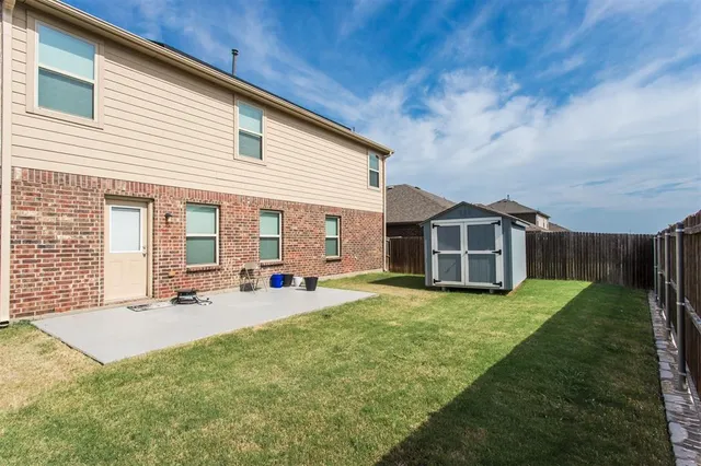 a view of a backyard with grass and a small pool