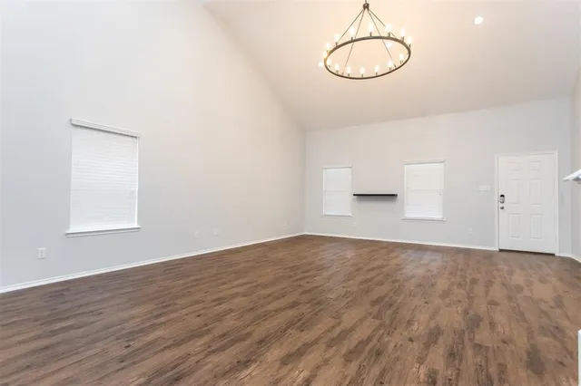 a view of empty room with wooden floor and window