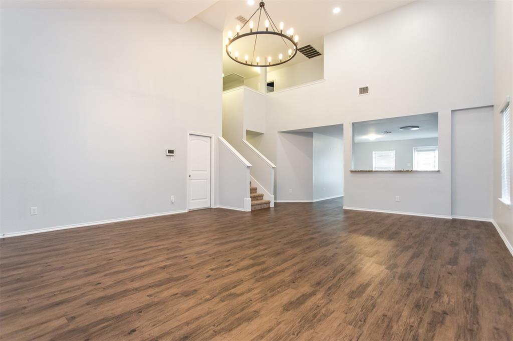 2103 Meadow Park Drive Princeton, TX 75407 - Photo 9 of 30 a view of an empty room with wooden floor and kitchen view