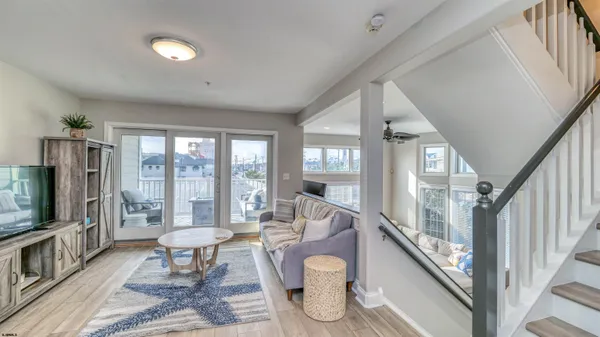a living room with furniture a flat screen tv and a floor to ceiling window
