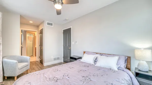 a bedroom with a bed ceiling fan and a window