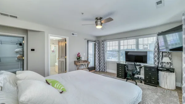 a bedroom with a bed and a flat tv screen on the dresser