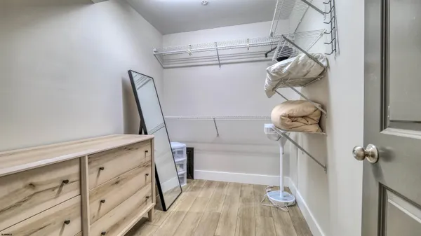 a view of walk in closet with clothes and shoes
