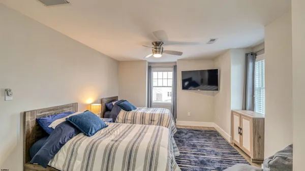 a bedroom with two beds and a flat screen tv