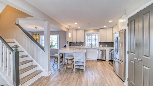 a kitchen with white cabinets and stainless steel appliances