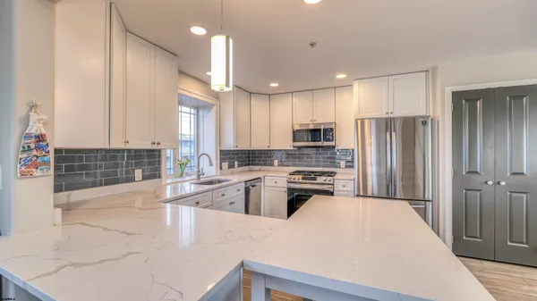 a large kitchen with cabinets and stainless steel appliances