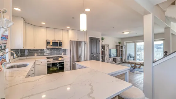 a large kitchen with kitchen island a stove a sink a refrigerator and cabinets