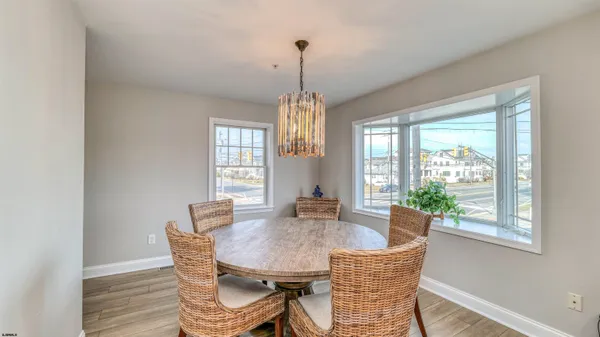 a dining room with furniture a chandelier and wooden floor