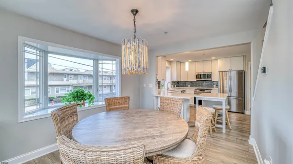 a dining room with furniture a chandelier and wooden floor