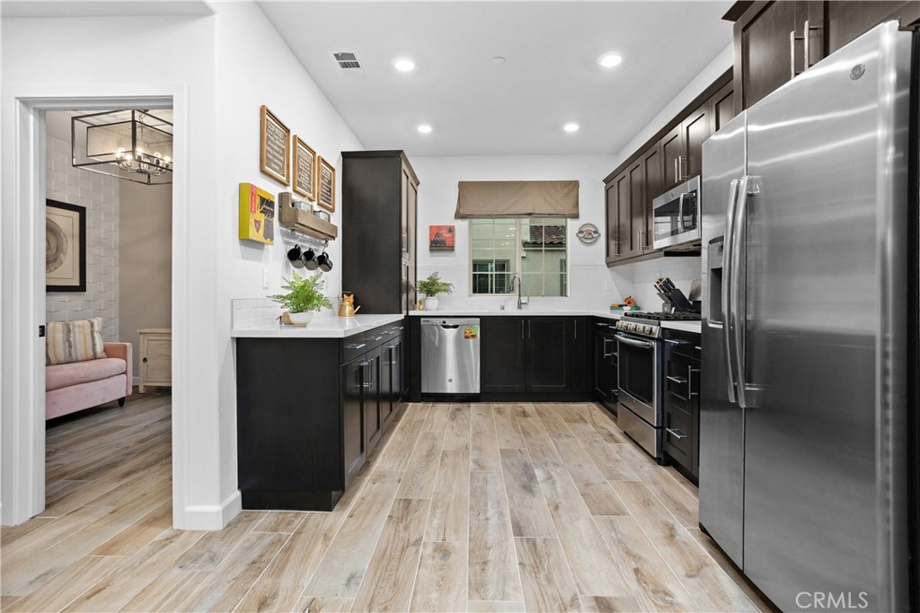 4366 Pacifica Way, Unit 7 Oceanside, CA 92056 - Photo 9 of 36 a kitchen with stainless steel appliances kitchen island granite countertop a refrigerator and a sink