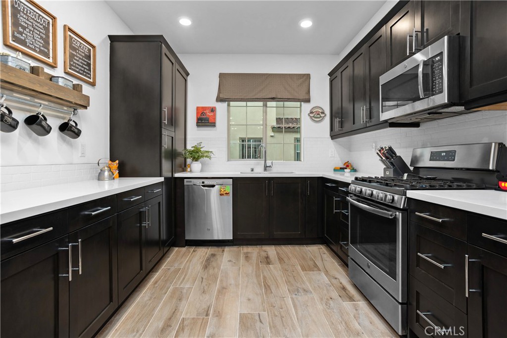 4366 Pacifica Way, Unit 7 Oceanside, CA 92056 - Photo 10 of 36 a kitchen with stainless steel appliances granite countertop a sink stove and refrigerator