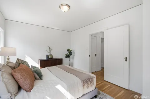 a bedroom with a bed and a lamp on the dresser