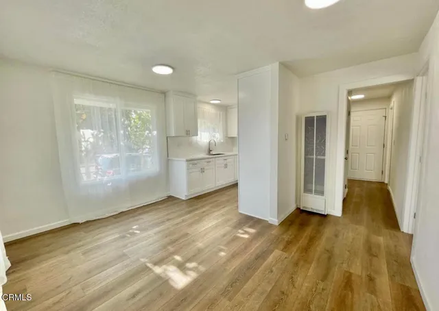a view of a kitchen with wooden floor and a window