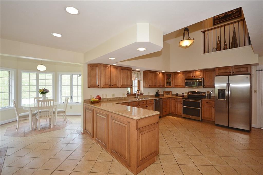 92 Chestnut Ridge Road Washington, PA 15301 - Photo 8 of 25 Quartz countertops, glazed maple cabinets, and stainless-steel appliances up the WOW factor inside this kitchen.