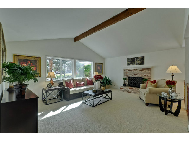 21841 McClellan Road Cupertino, CA 95014 - Photo 3 of 25 a living room with furniture a fireplace a potted plant and a large window