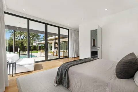 a bedroom with a bed and a large window