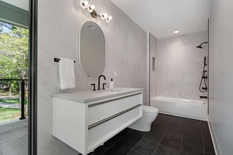 a bathroom with a sink a toilet and shower