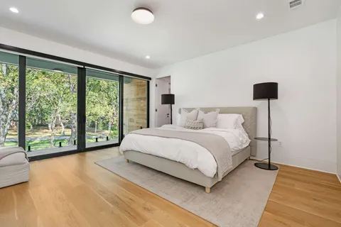 a bedroom with a bed and a large window