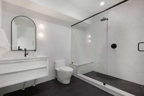 a spacious bathroom with a double vanity sink a toilet and a mirror