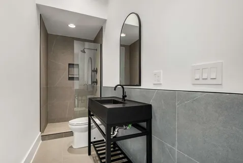 a bathroom with a toilet a sink and mirror