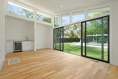 a view of an empty room with wooden floor and a fireplace