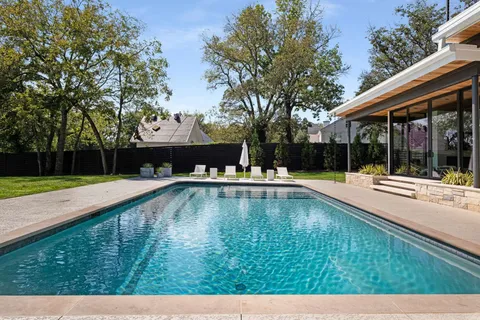 a swimming pool with outdoor seating and yard
