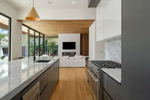 a kitchen with sink stove and view living room