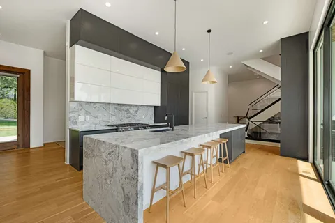 a kitchen with a stove and a wooden floor