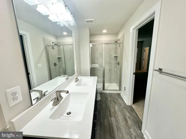 a view of a bathroom with a sink wooden floor and a mirror