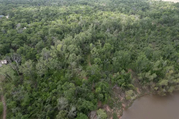 an aerial view of residential house with outdoor space and trees all around