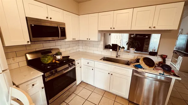 a kitchen with stainless steel appliances a stove a sink and a microwave
