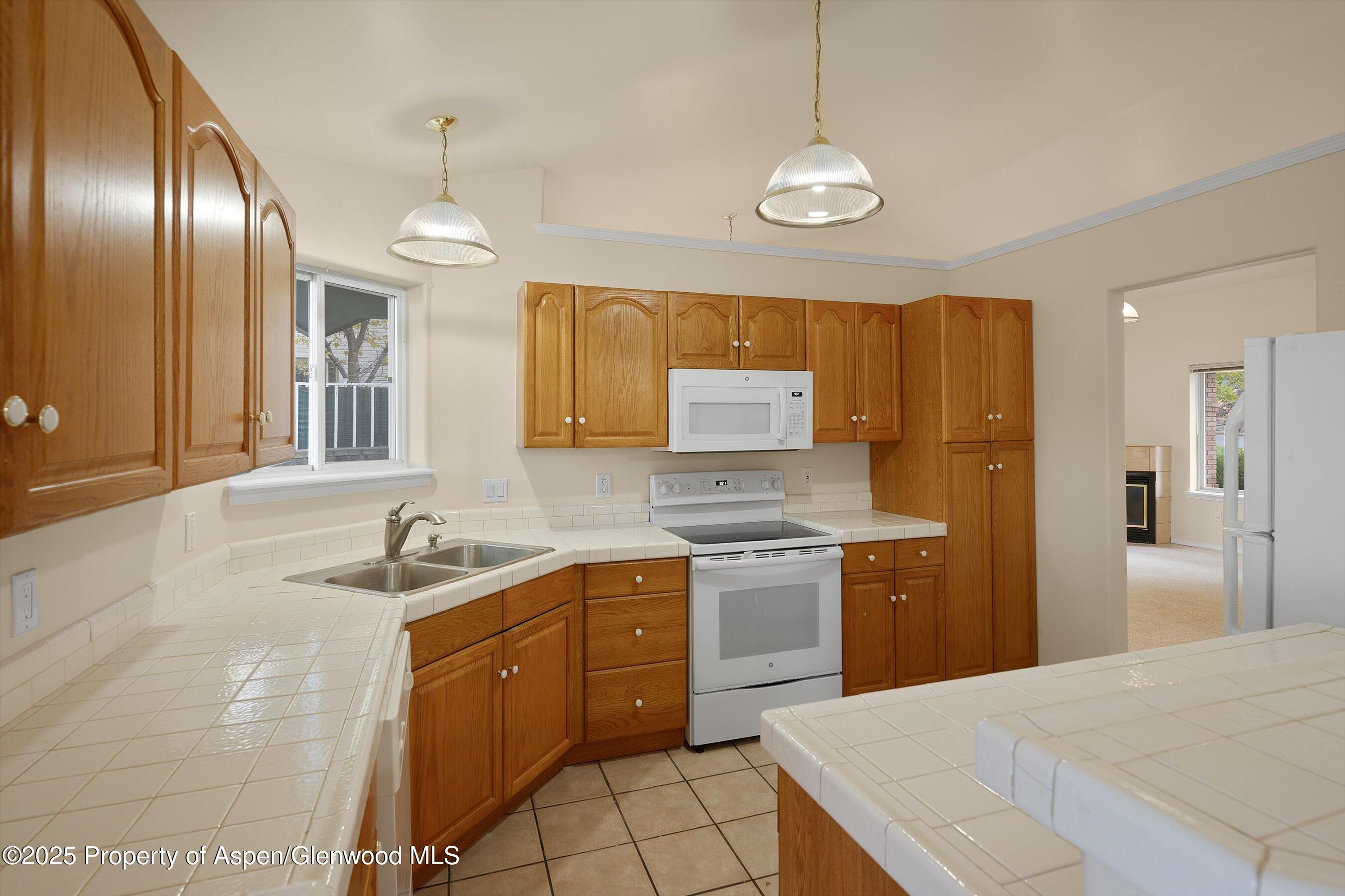 634 East First Street New Castle, CO 81647 - Photo 16 of 46 a kitchen with granite countertop stainless steel appliances a sink stove and refrigerator