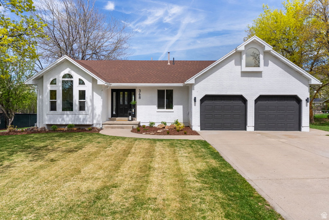 368 Spring Creek Road Providence, UT 84332 - Photo 1 of 45 Single story home featuring brick siding, driveway, a front lawn, a porch, and a garage