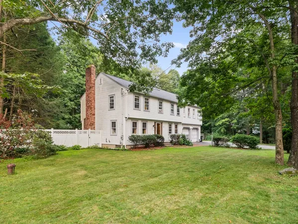 a view of a house with a big yard and large trees