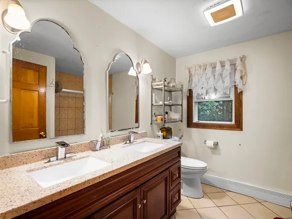 a bathroom with a granite countertop sink mirror vanity and toilet