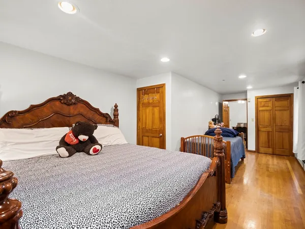 a bedroom with a bed and wooden floor