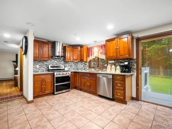 a kitchen with stainless steel appliances granite countertop a stove a sink and a refrigerator