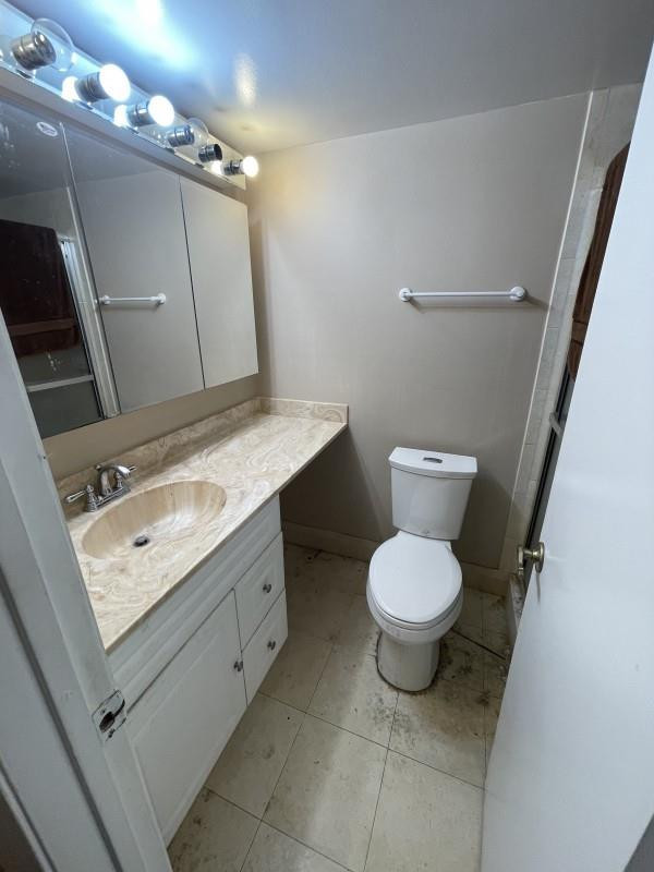 275 Gate Road, Unit 204 Hollywood, FL 33024 - Photo 5 of 6 a bathroom with a granite countertop toilet sink and mirror