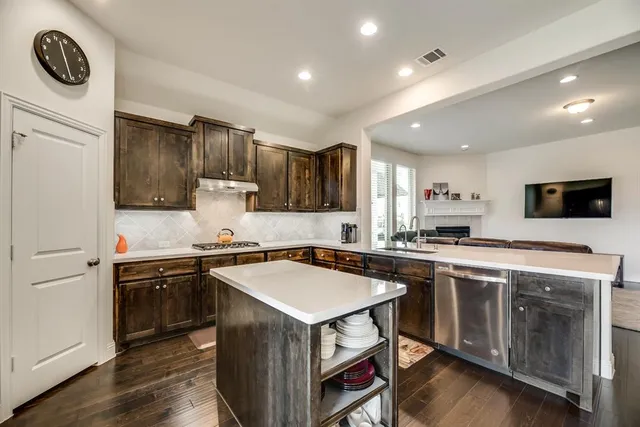a kitchen with a stove sink and cabinets