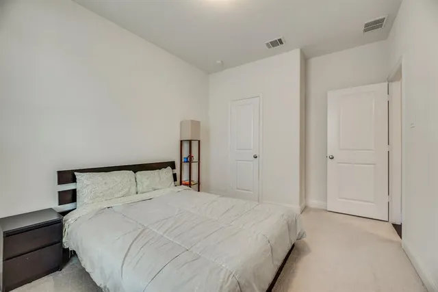 a bedroom with a bed and a night stand