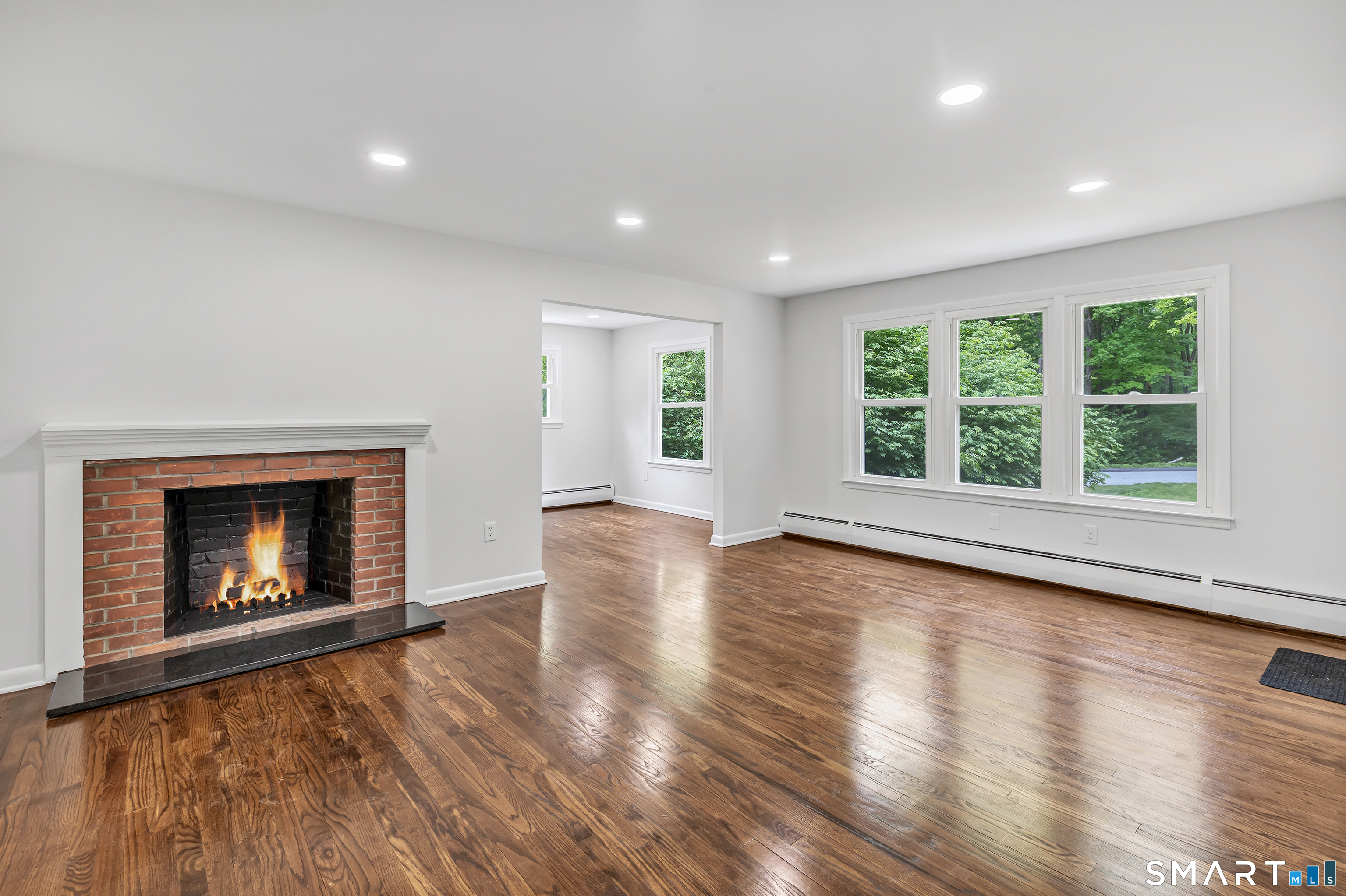 7 Longview Road Newtown, CT 06482 - Photo 4 of 40 an empty room with wooden floor fireplace and windows