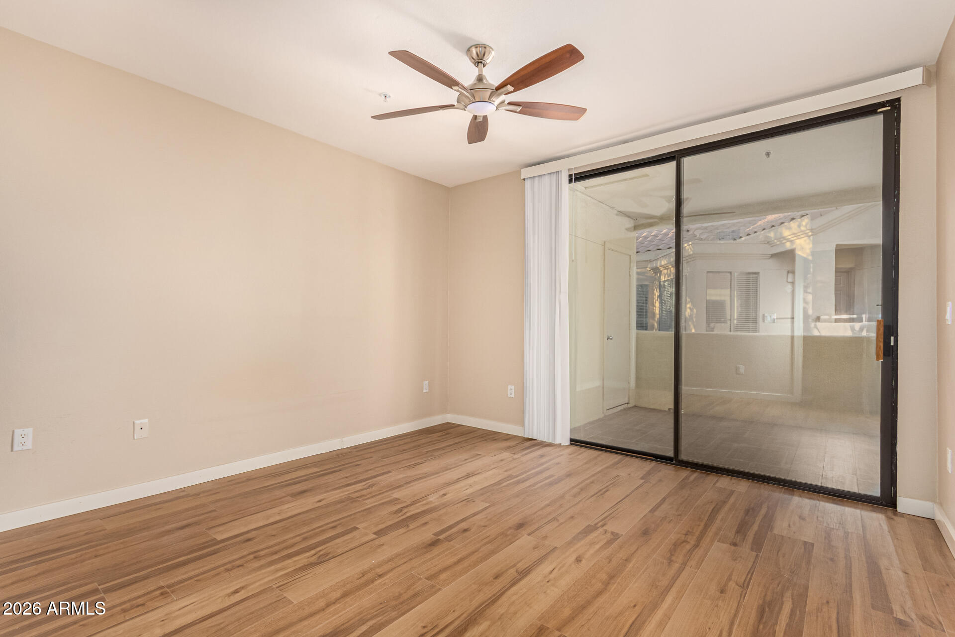 7575 East Indian Bend Road, Unit 2036 Scottsdale, AZ 85250 - Photo 11 of 29 an empty room with wooden floor and a ceiling fan