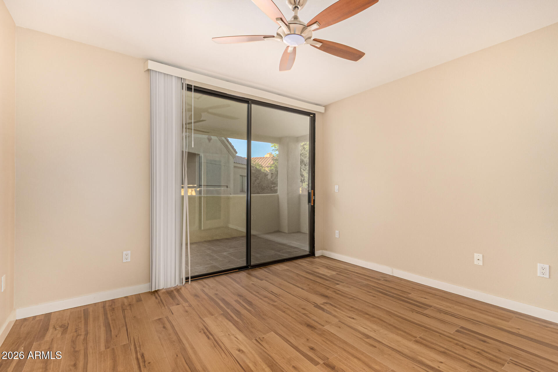 7575 East Indian Bend Road, Unit 2036 Scottsdale, AZ 85250 - Photo 12 of 29 an empty room with wooden floor fan and windows