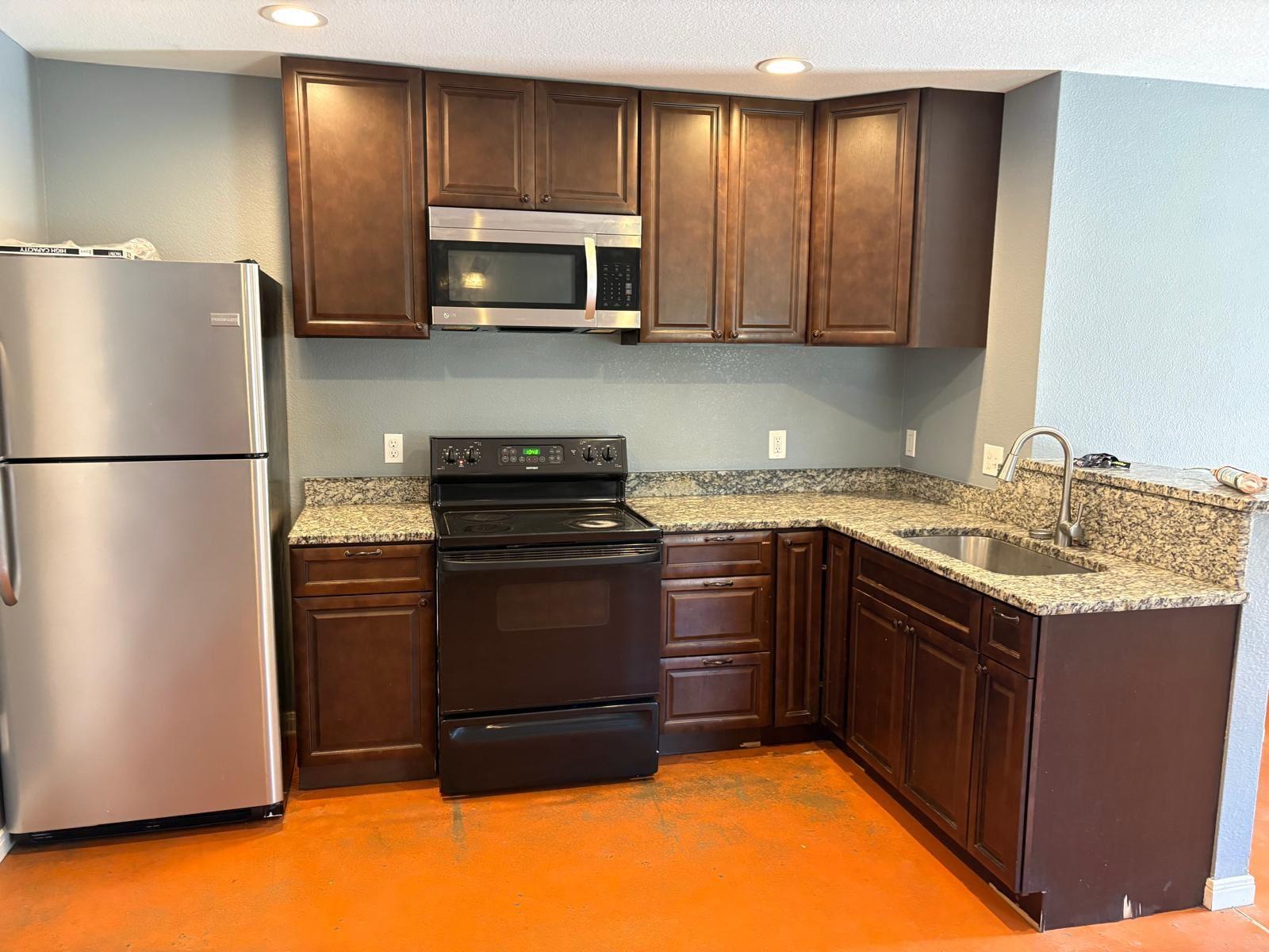 1403 Strickland Street Waco, TX 76705 - Photo 4 of 11 a kitchen with stainless steel appliances granite countertop a refrigerator a stove a sink and a microwave